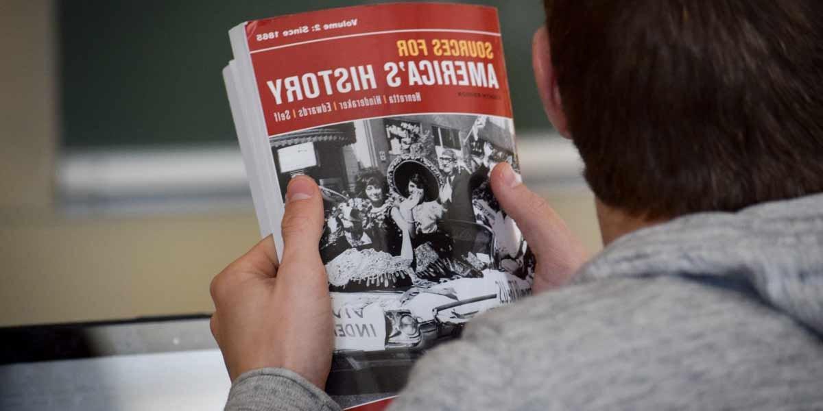 A student holds a history textbook in class
